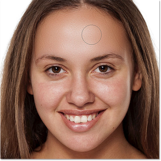 Painting to reveal the smooth skin in the woman's forehead in Photoshop
